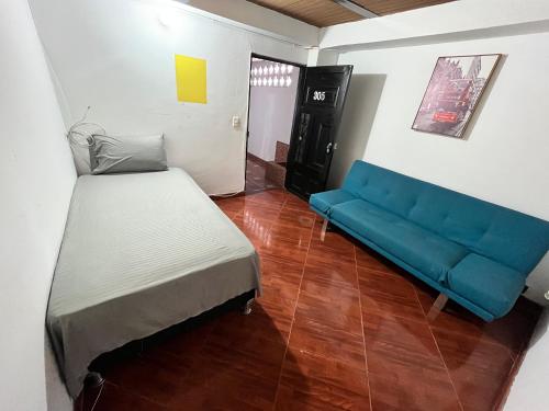 Habitación con cama y sofá azul en Aparta Suite Torre De Prado 305, en Medellín