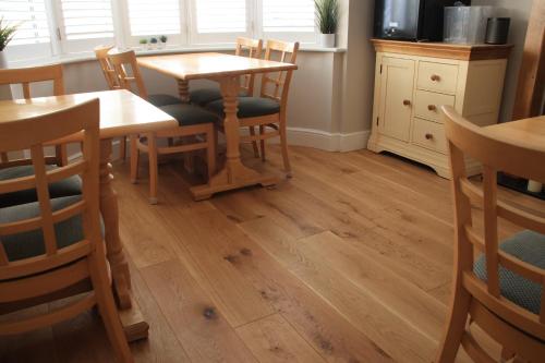 a dining room with wooden tables and chairs at Magnolia House in Royston