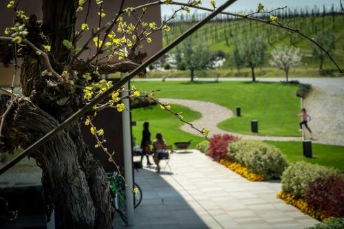 a group of people walking down a walkway in a park at COBUE "Wine resort & Spa" in Pozzolengo