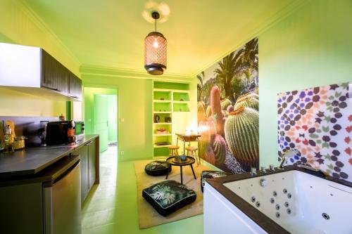 una cocina con paredes verdes y una gran pintura en la pared en luxury Magic Cactus Garden, Paris 0rly avec jacuzzi, en Vigneux-sur-Seine