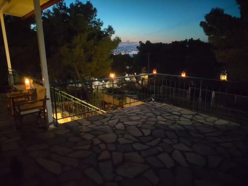 a patio with a table and a fence at night at My Place 2 in Agios Spyridon