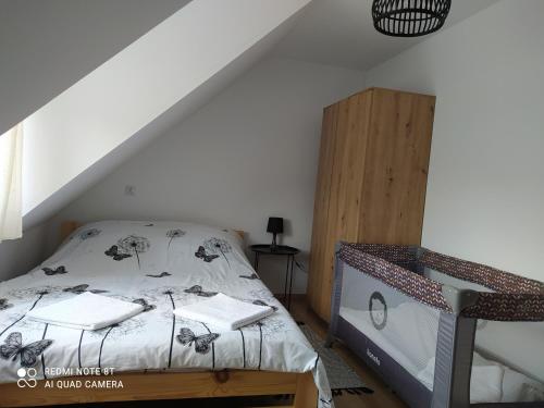 a bedroom with a bed and a loft at Domek przy parku in Susiec