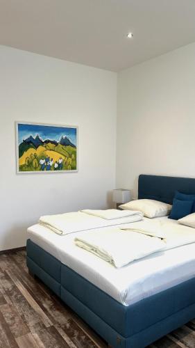 two beds in a room with a painting on the wall at City Zimmer - Appartement Dina Mariner in Lienz