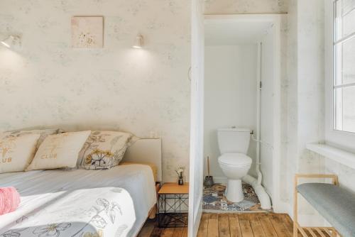 een slaapkamer met een bed en een toilet bij Bord de Rance - Le Gîte de Louise in Pleudihen-sur-Rance