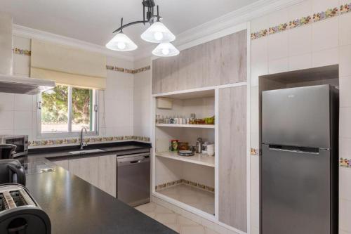 a kitchen with a stainless steel refrigerator and a sink at Villa Sa Llimonera by Slow Villas in Es Llombards