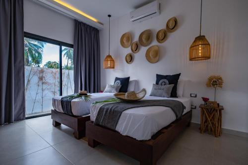 a bedroom with two beds and a large window at Villa Manglar in Las Terrenas
