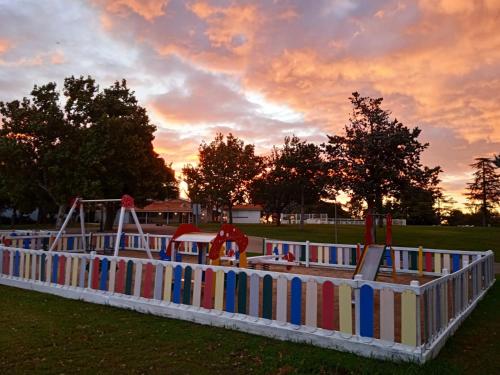 un parque infantil al atardecer con aoc en Bungalows Zaragoza Camping, en Zaragoza