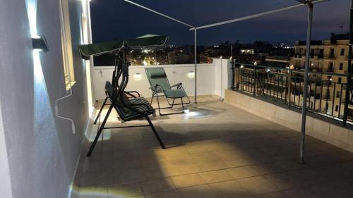 two chairs sitting on a balcony at night at Rooftop Acropolis Apartment Athens in Athens