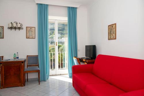 a living room with a red couch and a window at Palatium Mari in Capri