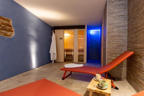 een kamer met een rode stoel en een tafel bij terracielo. in Faenza