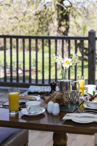 The Lake Country House Hotel & Spa في لانغامارتْش ويلز: طاولة خشبية عليها طعام ومشروبات للإفطار