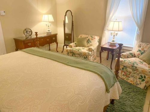 ein Schlafzimmer mit einem Bett, einem Stuhl und einem Spiegel in der Unterkunft Elegant 2BR Apt w 2 Bathrooms in Historic Hamlet by Berkshires & Hudson Valley, Walk to Restaurants in Hillsdale
