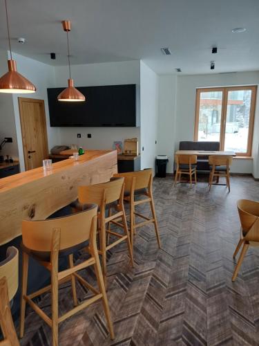 a room with chairs and a bar and a table at Apartmán 107 Ovruč in Štrbské Pleso