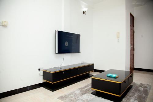 a living room with a tv on a white wall at MIKOCHENI APARTMENT in Dar es Salaam