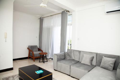 uma sala de estar com um sofá e uma mesa em MIKOCHENI APARTMENT em Dar es Salaam
