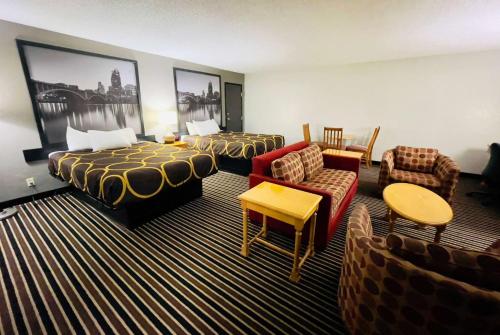 een hotelkamer met 2 bedden en een bank bij Super 8 by Wyndham Shakopee in Shakopee