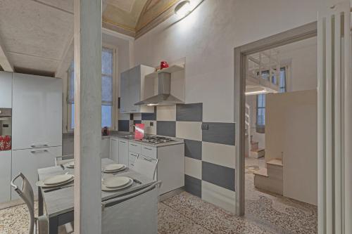 uma cozinha com armários brancos e um forno com placa de fogão em San Bernardo Loft by Wonderful Italy em Gênova