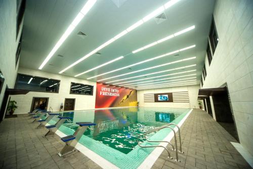 a swimming pool in a building with chairs around it at Jacaranda Heights in Islamabad