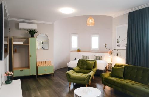 Vali Byron في خليج بايرون: غرفة نوم مع سرير وغرفة معيشة مع أريكة