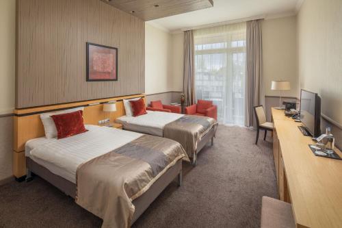 una camera d'albergo con due letti e una televisione di Mamaison Hotel Andrassy Budapest a Budapest