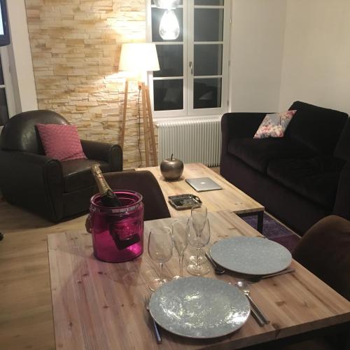 una sala de estar con una mesa con copas de vino en Duplex de charme Laguna - Centre Niort Historique, en Niort