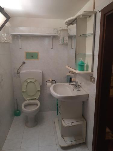 La petite salle de bains est pourvue de toilettes et d'un lavabo. dans l'établissement Basement Home, à Domusnovas