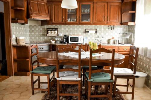 cocina con mesa de madera y sillas en Casa Raposo, en Miranda do Corvo