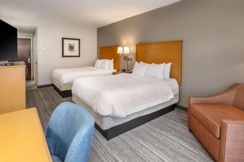 a hotel room with two beds and a couch at Hampton Inn & Suites Nashville-Vanderbilt-Elliston Place in Nashville