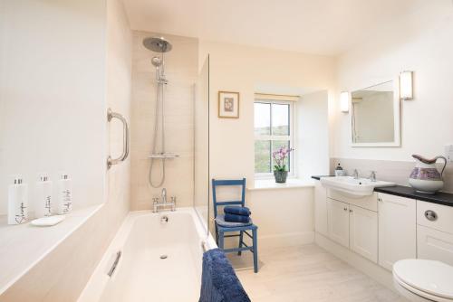 a bathroom with a tub and a toilet and a sink at The Bothy at Redheugh in Newcastleton