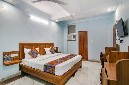 a bedroom with a bed and a flat screen tv at FabHotel Hari Residency in Chandīgarh