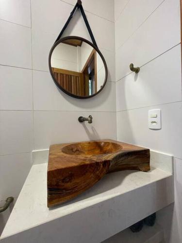 a bathroom with a wooden sink and a mirror at Casinha charmosa e muito verde em Bom Princípio in Toledo
