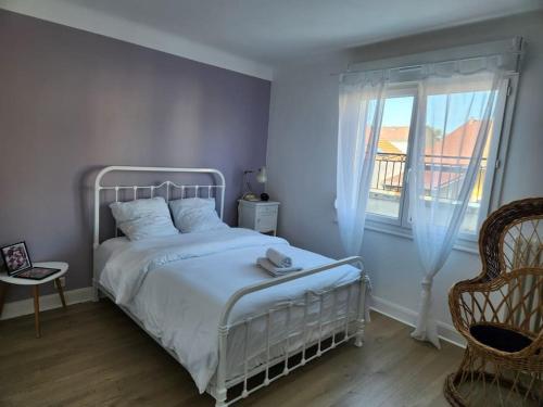ein Schlafzimmer mit einem weißen Bett und einem Fenster in der Unterkunft APPT LUMINEUX F3 QUARTIER CALME in Vichy