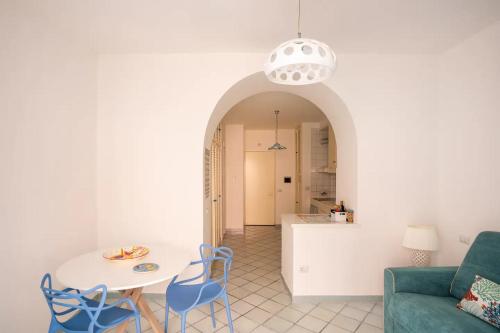 uma sala de estar com um sofá, uma mesa e cadeiras em Blue Vert Maison - al molo di Gaeta em Gaeta