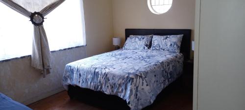 a bedroom with a bed with a blue and white comforter at Tita comfortable home in Johannesburg
