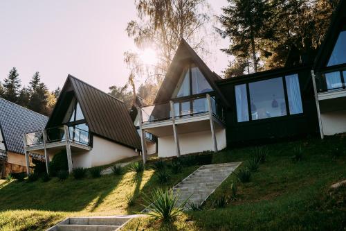 een huis op een heuvel met glazen deuren en ramen bij NOI Resort SPA - woda i las in Tęgoborze