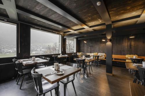 a restaurant with tables and chairs and large windows at Hotel Restaurant Bänklialp in Engelberg