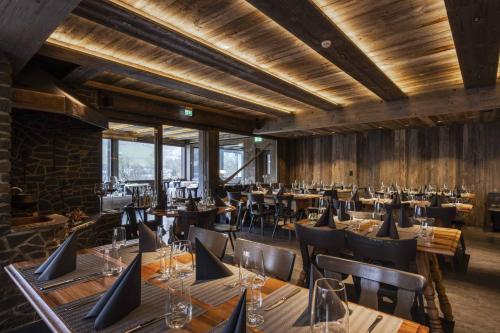 a restaurant with wooden walls and tables and chairs at Hotel Restaurant Bänklialp in Engelberg