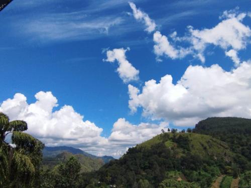 a blue sky with white clouds over a mountain at Rose Dale Homestay Ella in Ella