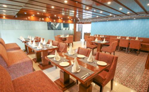 a dining room with tables and chairs in a restaurant at Hotel Cama in Chandīgarh
