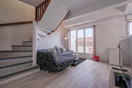 a living room with a couch and a staircase at Villepinte, 2-4 pers, proche aéroport Roissy CDG, parc des expositions, Disney in Villepinte