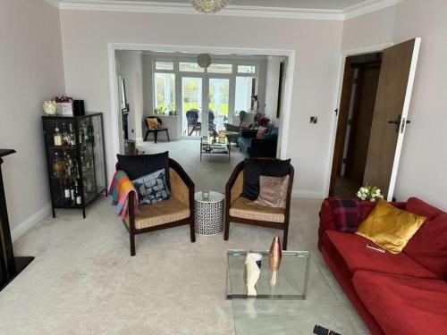 een woonkamer met een rode bank en stoelen bij Cosy and lovely 4-Bed House in Stanmore in Stanmore