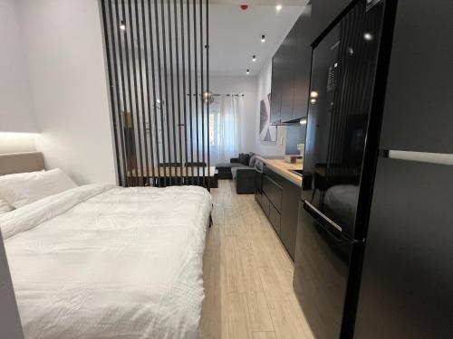 1 dormitorio pequeño con 1 cama y cocina en B1 Luxury Studio, en Alexandroupoli