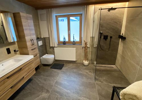 ein Bad mit einer Dusche, einem Waschbecken und einem WC in der Unterkunft Jägers Wohnung zwischen Ehrenberg und Neuschwanstein in Reutte