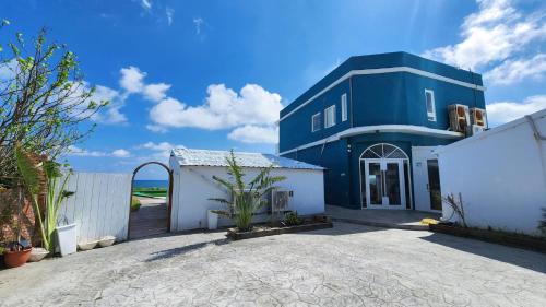 uma casa azul e branca com uma entrada em Joyful Lands em Manzhou