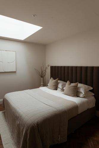 a bedroom with a large white bed with a skylight at HIDEOUT Hotel in Hull