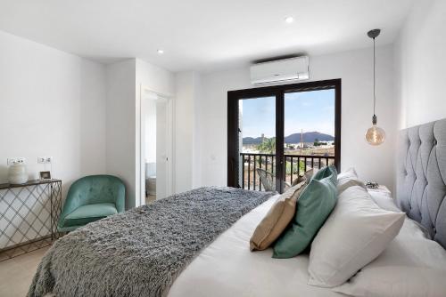 a bedroom with a large bed and a green chair at Casa El Molino in Yaiza