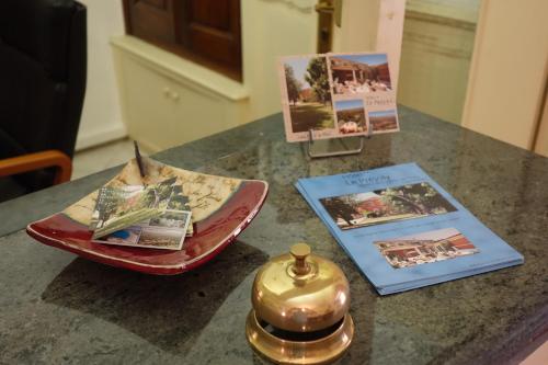 a counter with pamphlets and a bell on a table at Hotel le Préjoly in Saint-Vallier-de-Thiey