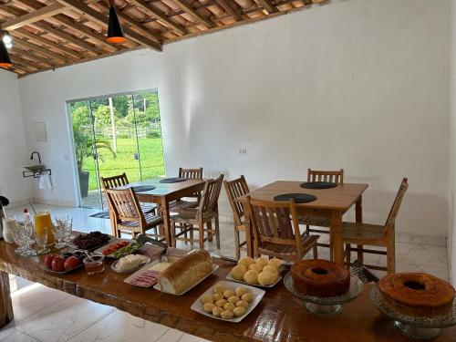 a dining room with a table with food on it at Pousada Império de Minas in Capitólio