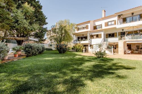 a large apartment building with a green yard at Paradise Suites in Carcavelos