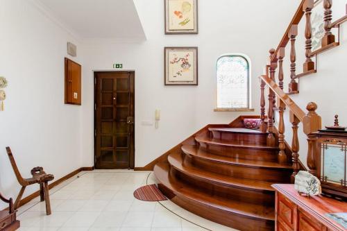 a hallway with a wooden staircase in a house at Paradise Suites in Carcavelos